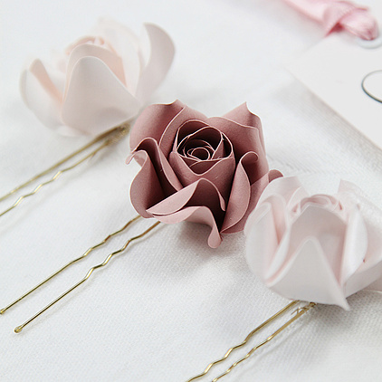 Haarschmuck aus handgearbeitete Papierrosen in verschiedenen rosatönen gestaltet. 